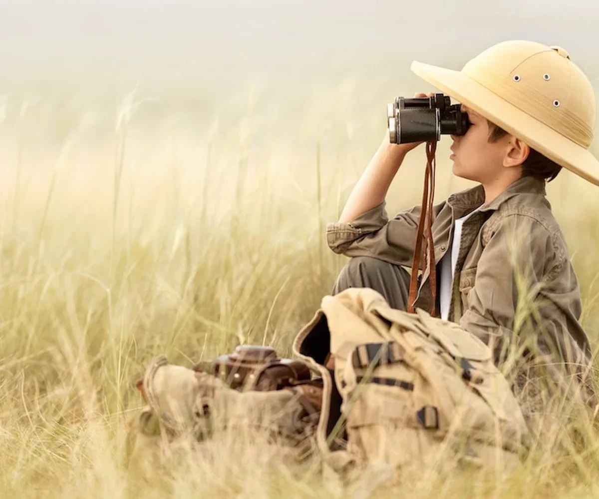 Niño observando aves con binoculares